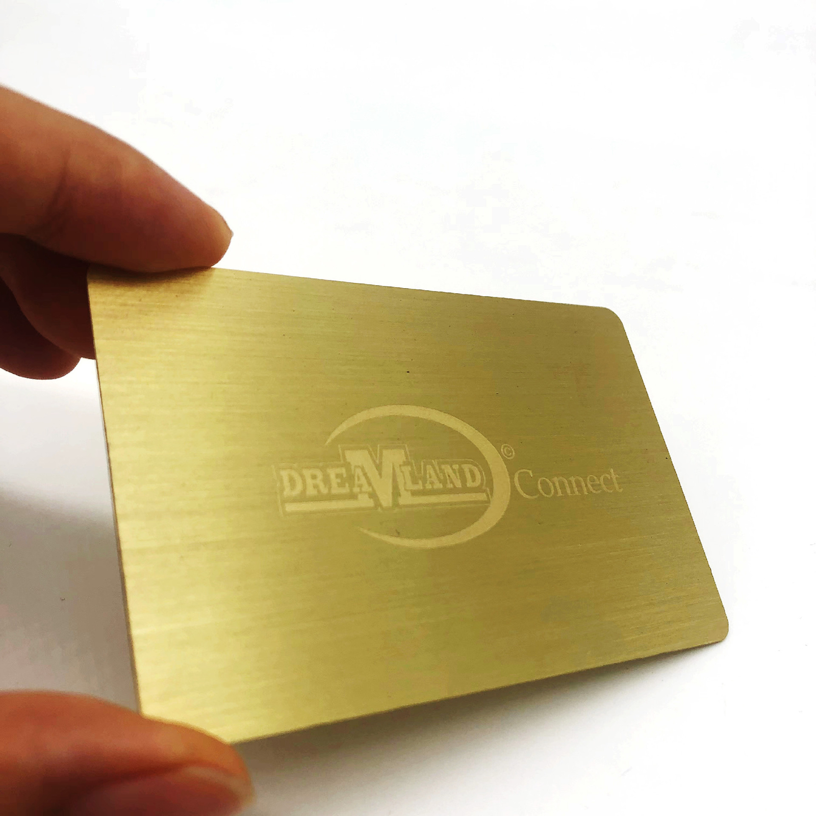 Vergulde metalen visitekaartjes met gegraveerd logo.