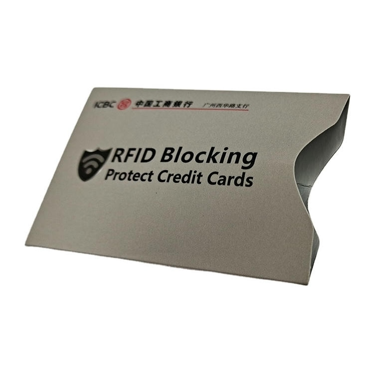 Grijze kussenverpakking met banklogo voor RFID-blokkeerhoesjes, bestemd voor distributie in reis- en portemonneesets.