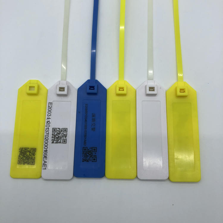 Rij RFID-kabelbindertags toont voorbeelden van lasermarkering met QR-code, vaste tekst en blanco panelen op gele, witte en blauwe tags.