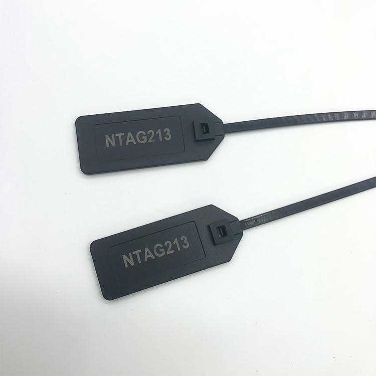 Twee zwarte RFID zip string tags model Z42528-1 zijn laser gemarkeerd NTAG213 en diagonaal weergegeven om de identificatie van de chip op het label te illustreren.