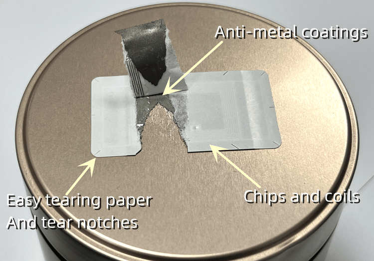 Deze afbeelding toont een gescheurd fragiel RFID-label op een metalen deksel, met aanduidingen voor de chipspoel en de gemakkelijk scheurende papierlaag.