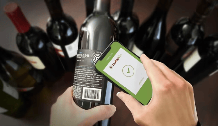 Deze afbeelding toont een hand die een wijnfles met een smartphone scant om de verpakkingsstatus via een RFID-gekoppeld platform te controleren.