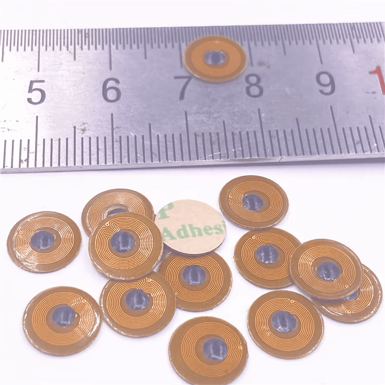 FPC10-1 micro NFC-tags naast een liniaal tonen de ronde 10mm-vorm voor montage in beperkte ruimte op metalen onderdelen.