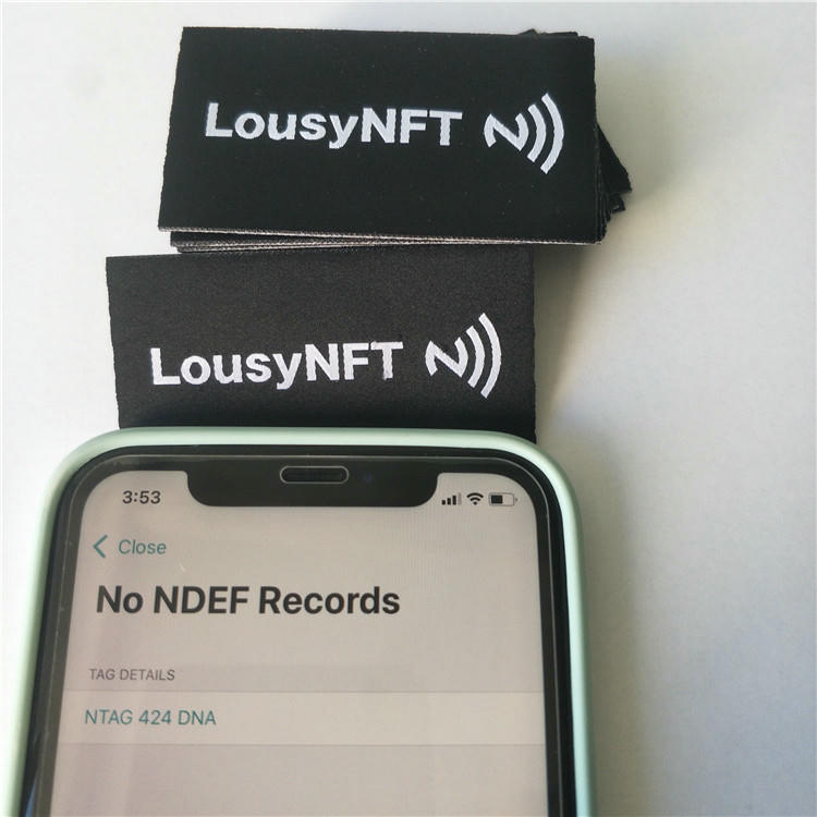 Close-up van een NFC-kledinglabel met fijne weefstructuur en geïntegreerde technologie.