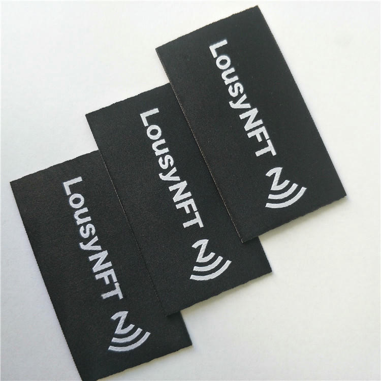 Een NFC-tag die op een stofmonster is genaaid als voorbeeld van een stevige bevestiging voor langdurig gebruik.