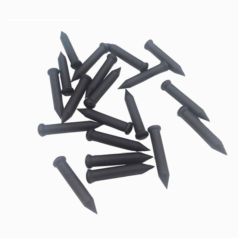 Deze afbeelding toont meerdere zwarte NAIL06-4 RFID-spijkertags verspreid op een witte achtergrond voor bulkweergave.